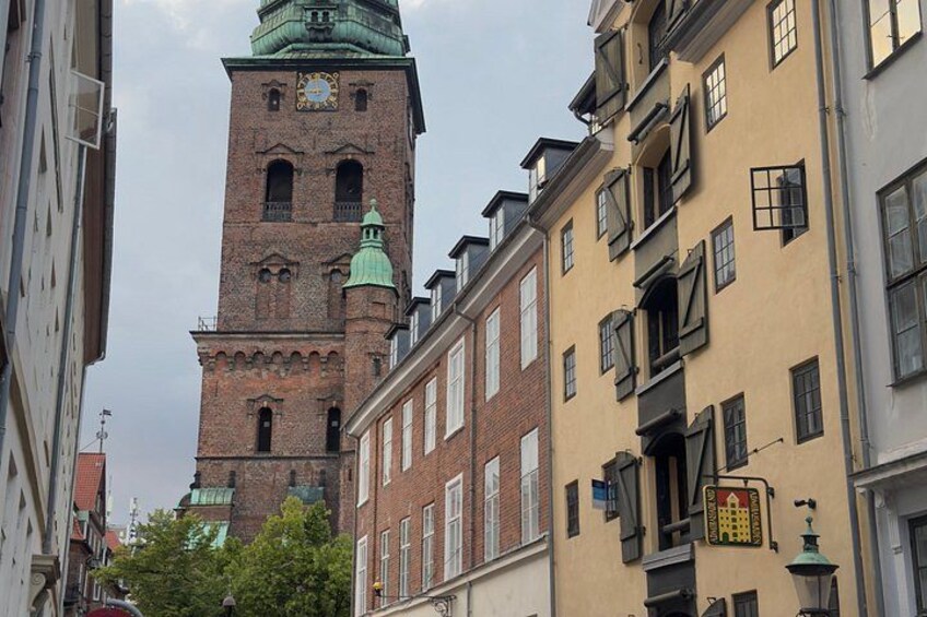 A historic tower with a clock, surrounded by traditional buildings. 5