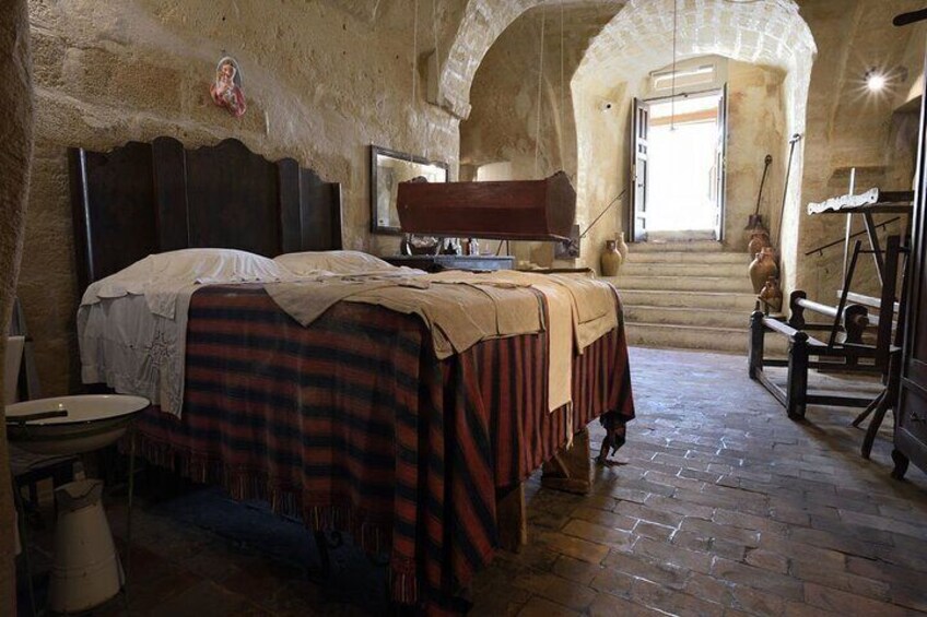 A rustic bedroom with a bed, a wooden chair, and a table. 4