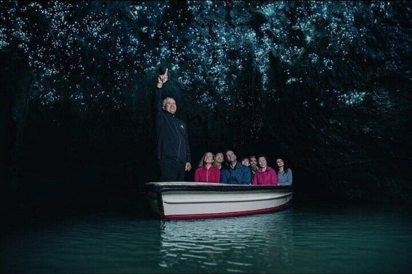 A boat with people on a body of water surrounded by trees. 5