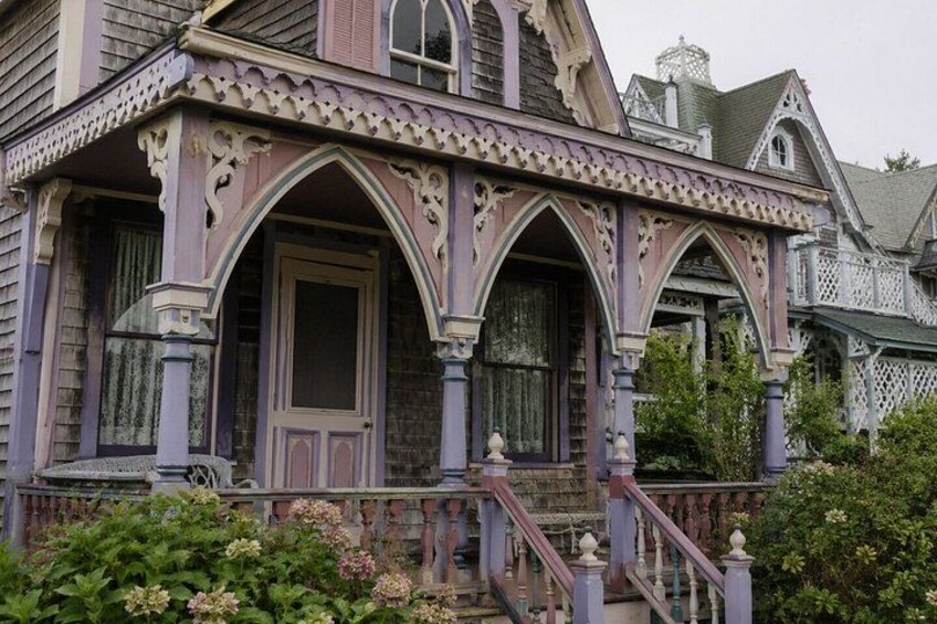 A Victorian-style house with ornate woodwork, a porch with a railing, and a staircase leading to the entrance. 4