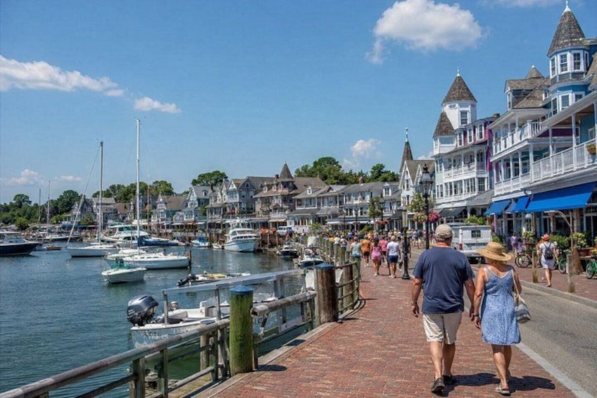 A waterfront promenade with boats docked, historic buildings, and people walking. 5