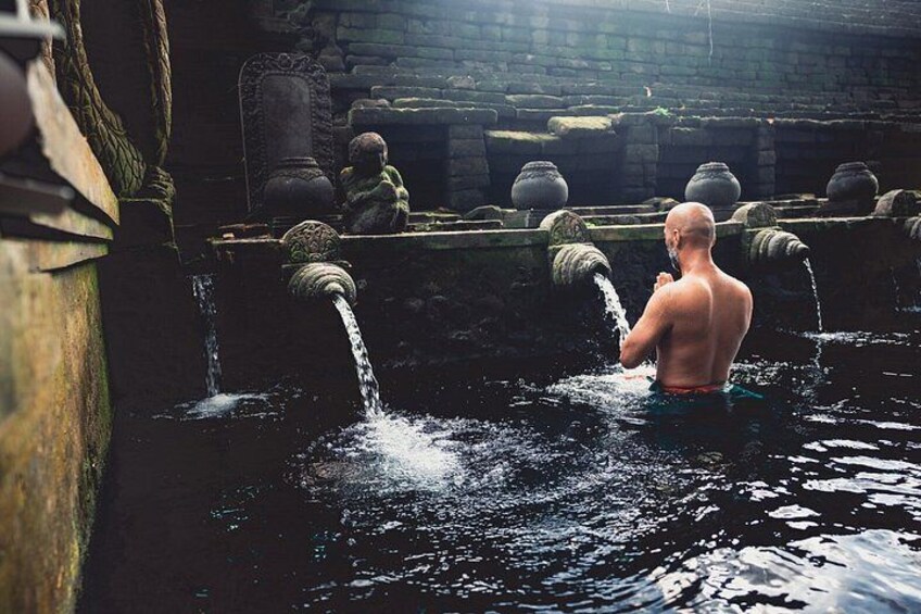A man in a historical setting with water flowing from stone structures. 3