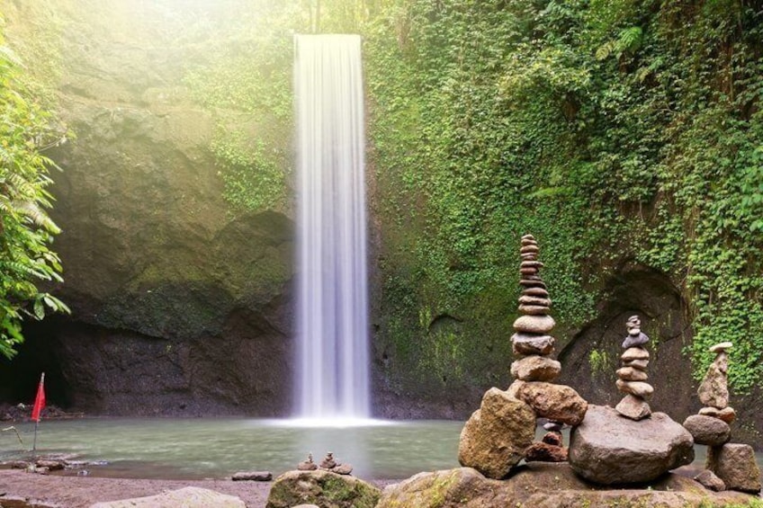 A waterfall, stacked rocks, and a forested area. 5