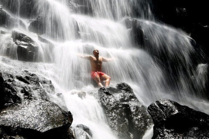 A person standing on rocks with water flowing over them. 2