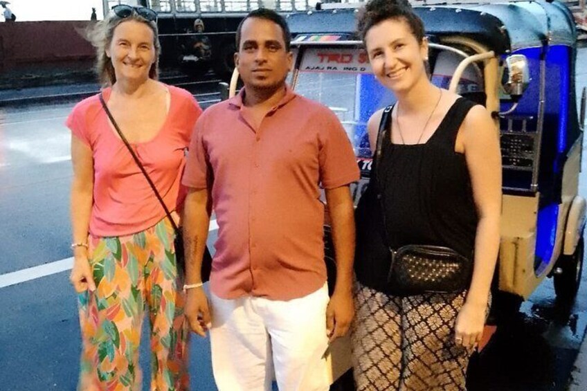 Three people standing in front of a blue auto-rickshaw. 2