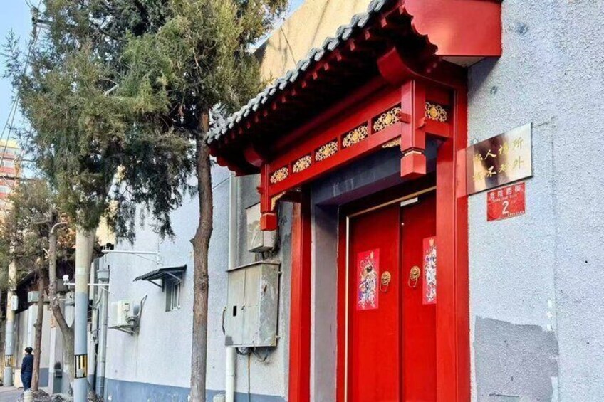 A red traditional building with a tiled roof, a signboard, and a tree in the background. 3
