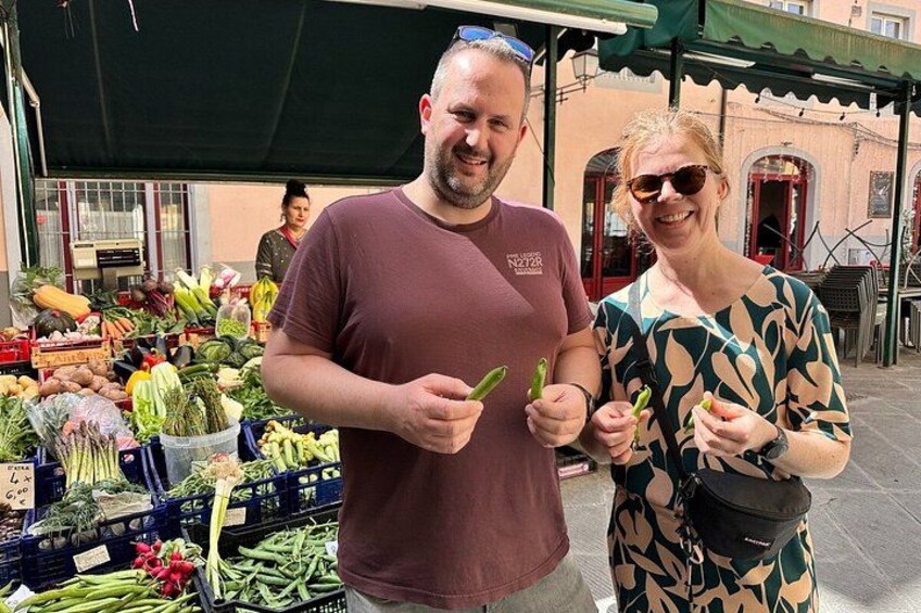 Two people at an outdoor market with fresh produce. 4