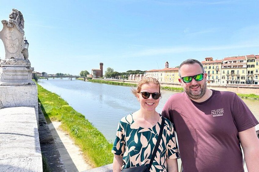 A river with a statue on the left, buildings in the background, and a clear sky. 2