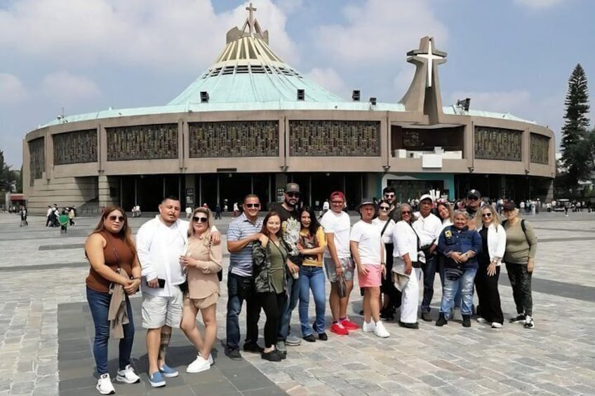 A group of people standing in front of a large church with a cross on top. 5