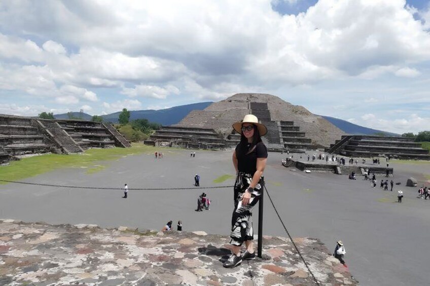 A person standing on a platform with ancient ruins in the background. 5