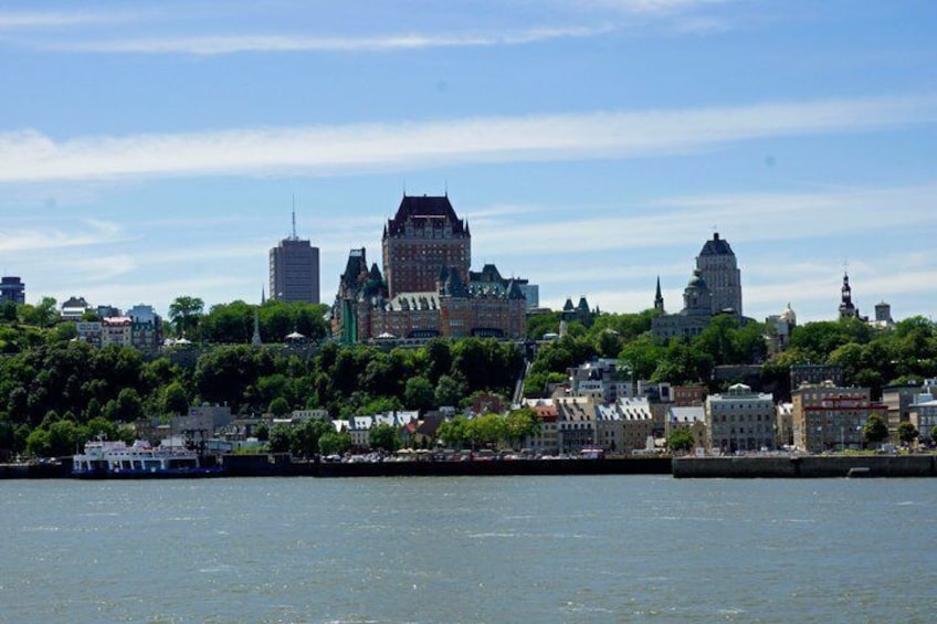 A city skyline with historic buildings, a river, and a boat. 4