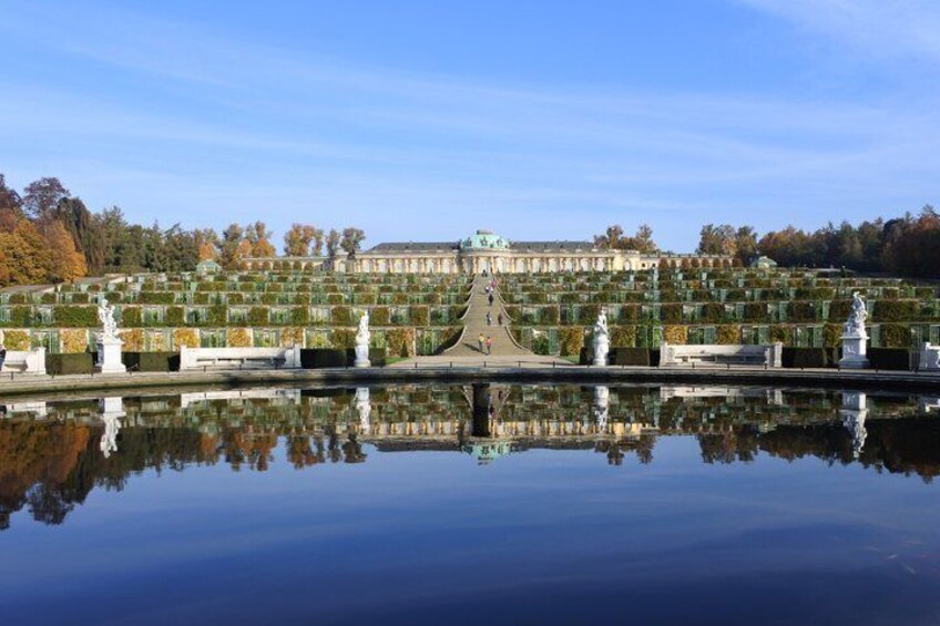 A grand palace with a symmetrical garden and a reflecting pool. 1