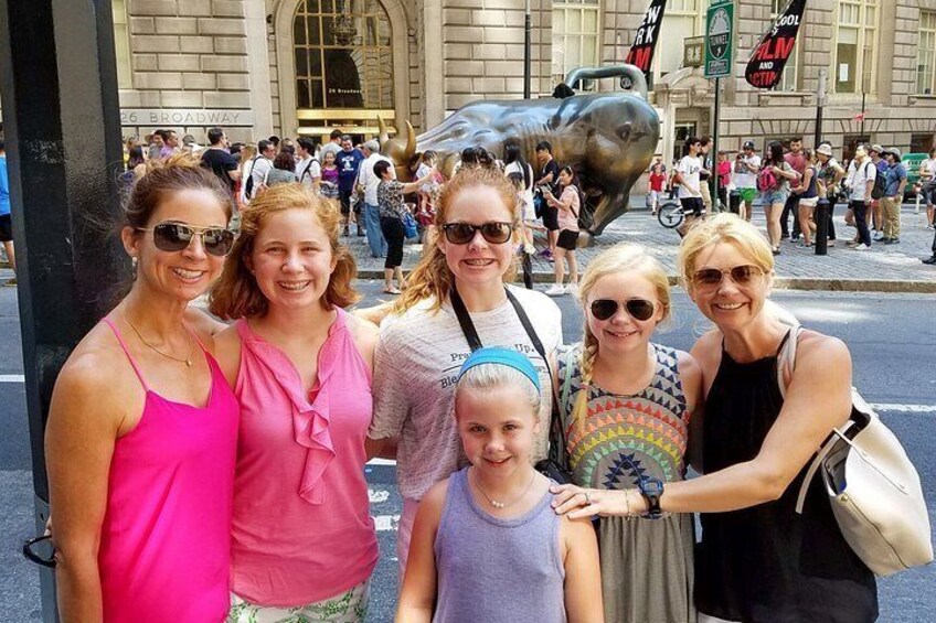 A group of people posing in front of a sculpture of a shark. 3
