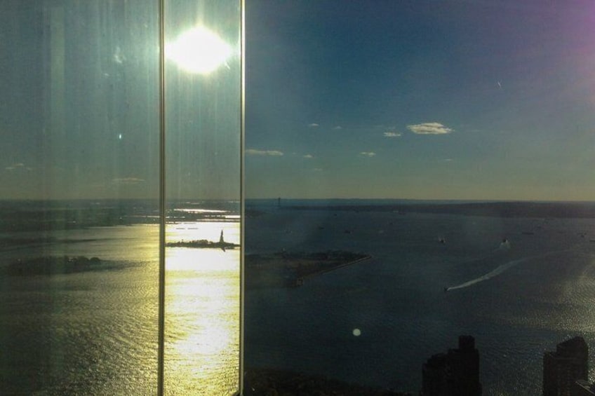 A body of water reflecting sunlight, a distant shoreline, and a clear sky. 5