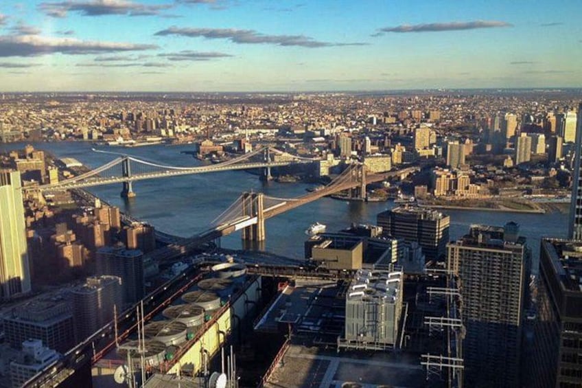 A cityscape with a prominent bridge spanning a river, dense urban buildings, and a clear sky. 3
