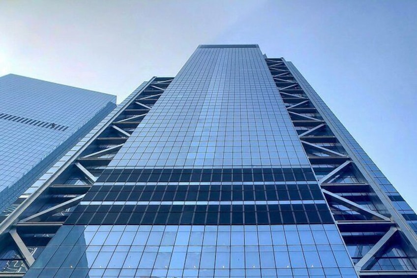 A tall skyscraper with a grid of windows and a steel framework. 4