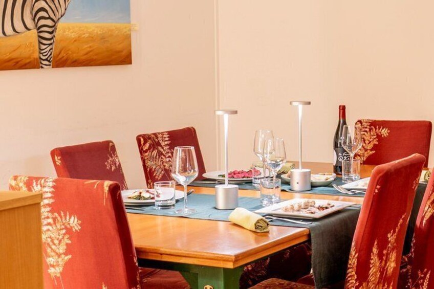 A dining table set with red chairs, wine glasses, and a bottle. 2
