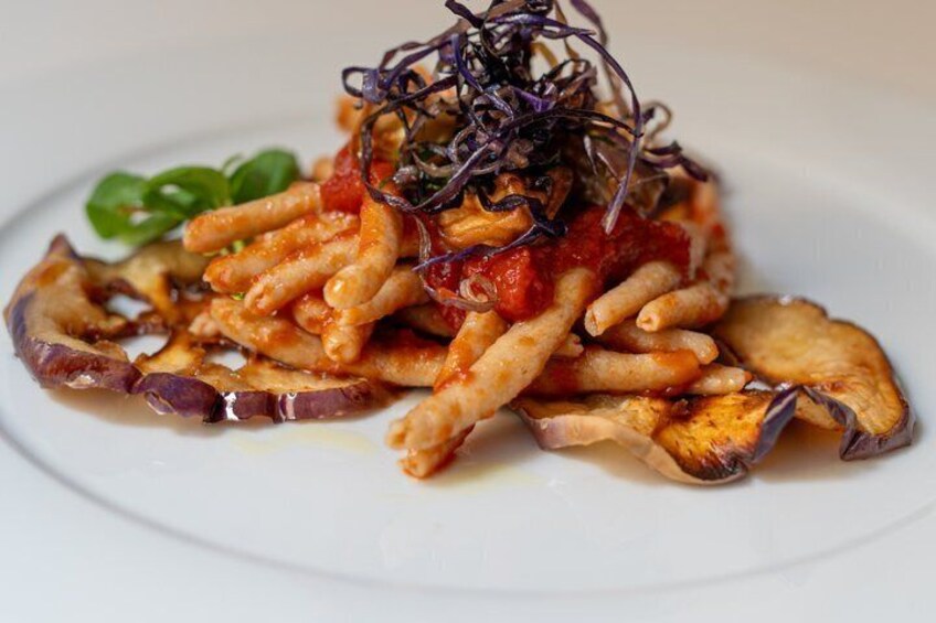 A plate of pasta with mushrooms and a garnish of purple leaves. 5