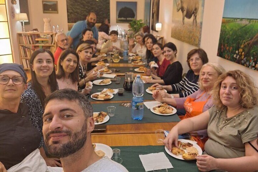 A group of people seated at a long table in a restaurant, enjoying a meal together. 1