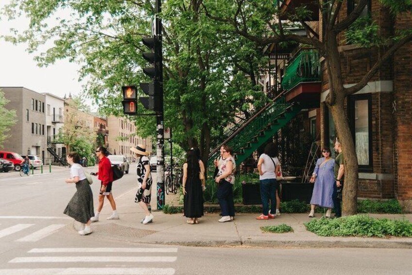 Pedestrians crossing a street, a traffic light, and buildings with a fire escape. 2