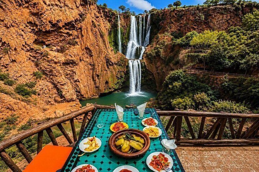 A table with food and a waterfall in the background. 1