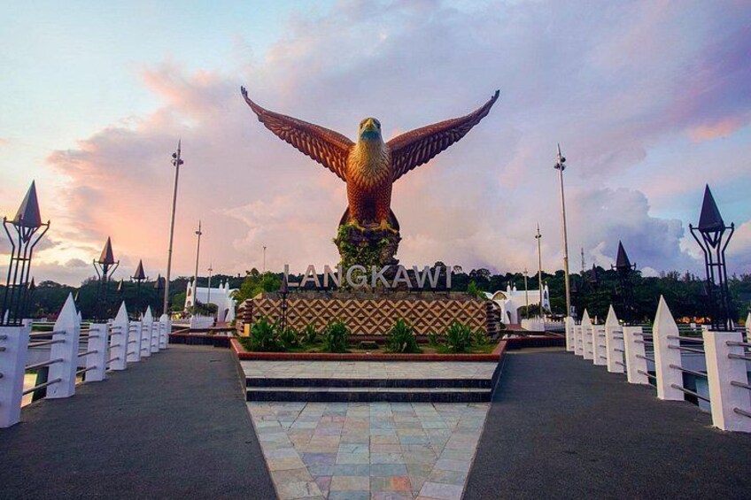 A large golden eagle statue with outstretched wings, a white fence, and a sign that reads 'LANGKAWI.' 5