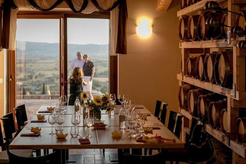 A dining table set with wine glasses and a view of a vineyard. 2