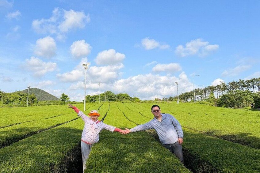 Two people holding hands in a green field with a clear sky. 3