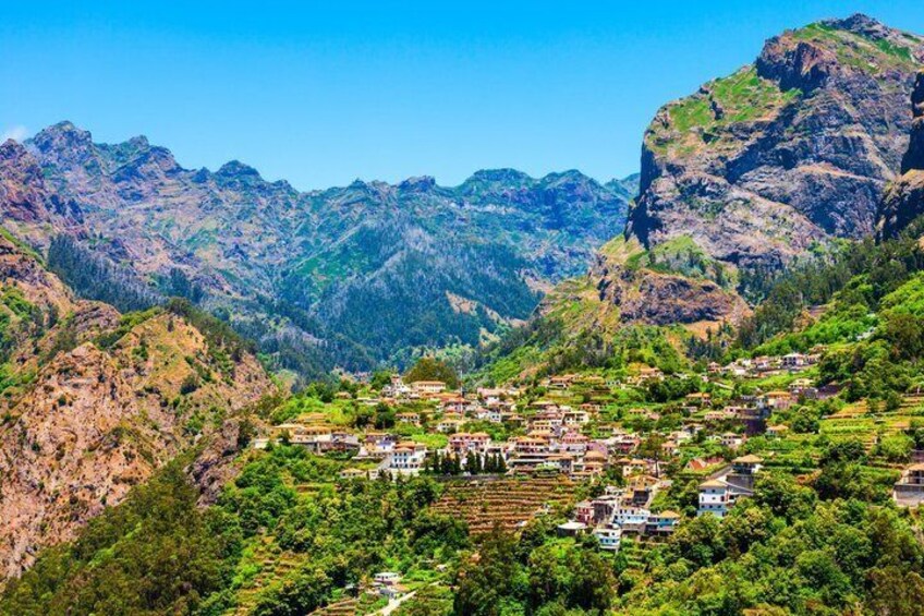 A mountainous landscape with terraced fields and scattered houses. 1