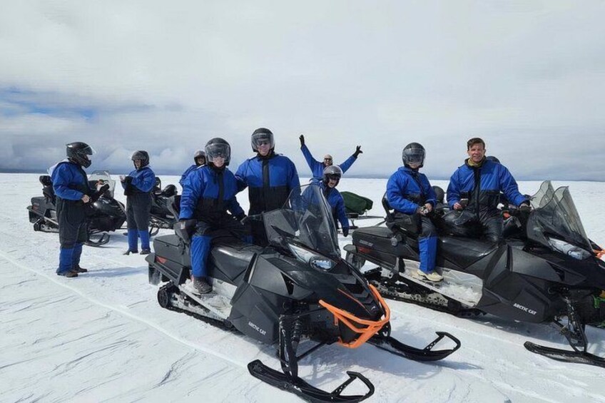 A group of people on snowmobiles on a snowy landscape. 3