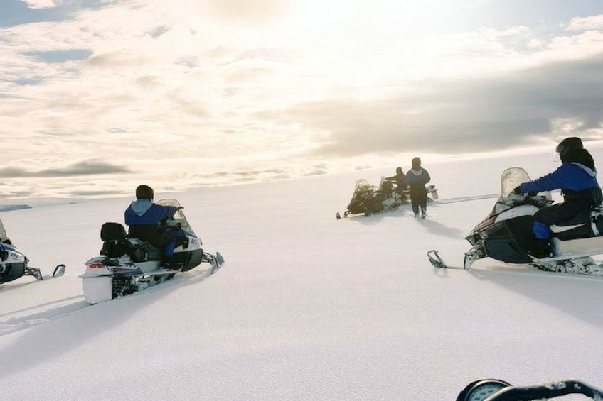 Snowmobiles on a snowy landscape with a cloudy sky. 5