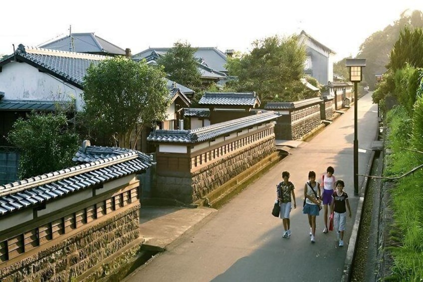 A traditional street with tiled roofs, stone walls, and a pathway. 5