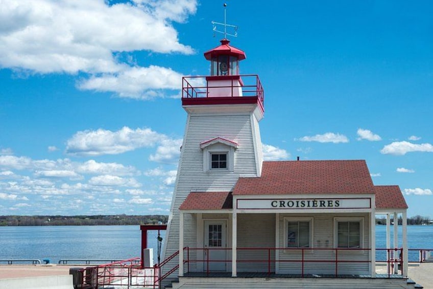 A lighthouse with a red roof and white walls, named 'CROISIÈRES,' by a body of water. 2
