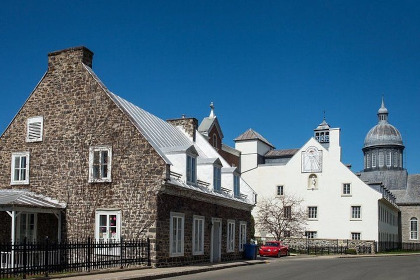 A historic stone building with a white facade and a dome structure in the background. 5