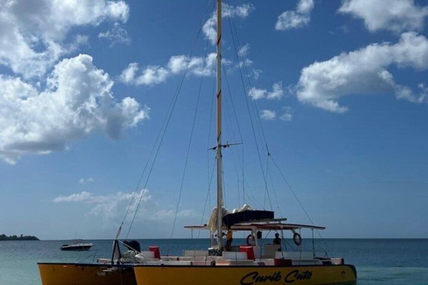 A yellow boat named 'Clyde Cruise' on calm waters with a clear sky and a distant island. 1