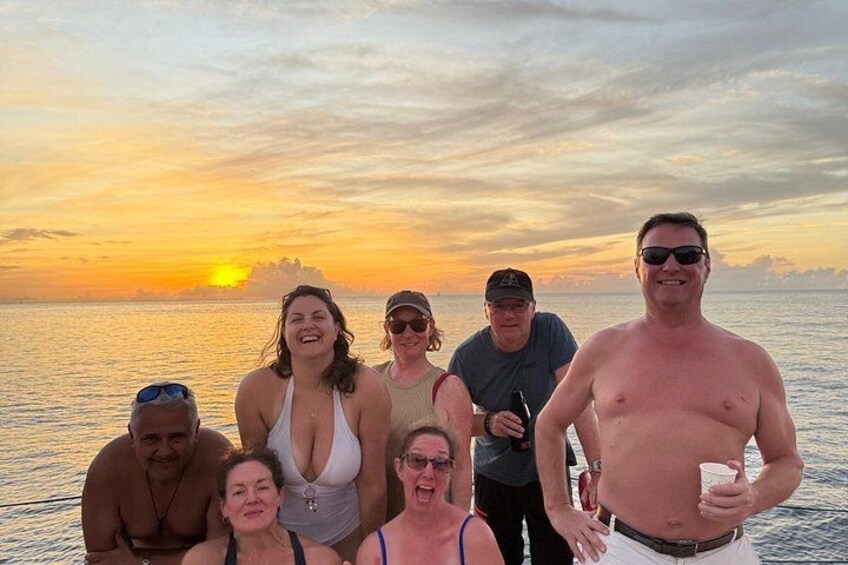 A group of people on a boat at sunset. 2