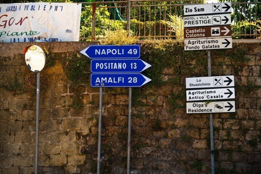 Directional signs for NAPOLI, POSITANO, and AMALFI with distances. 2