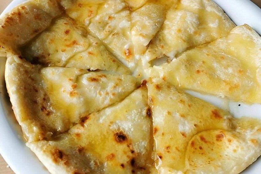 A close-up of a baked dish with a golden-brown crust and melted cheese. 5