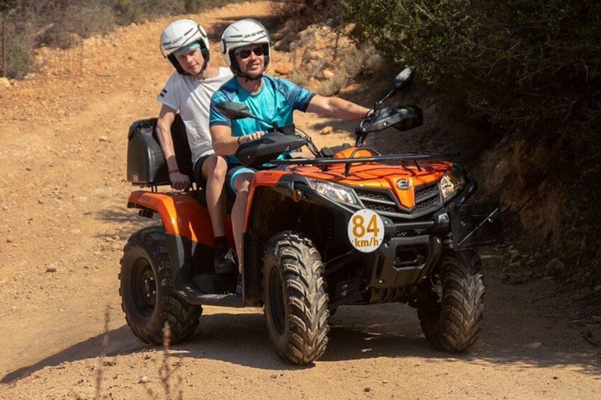 Two people on an ATV with a speed limit sign of 84 km/h. 3