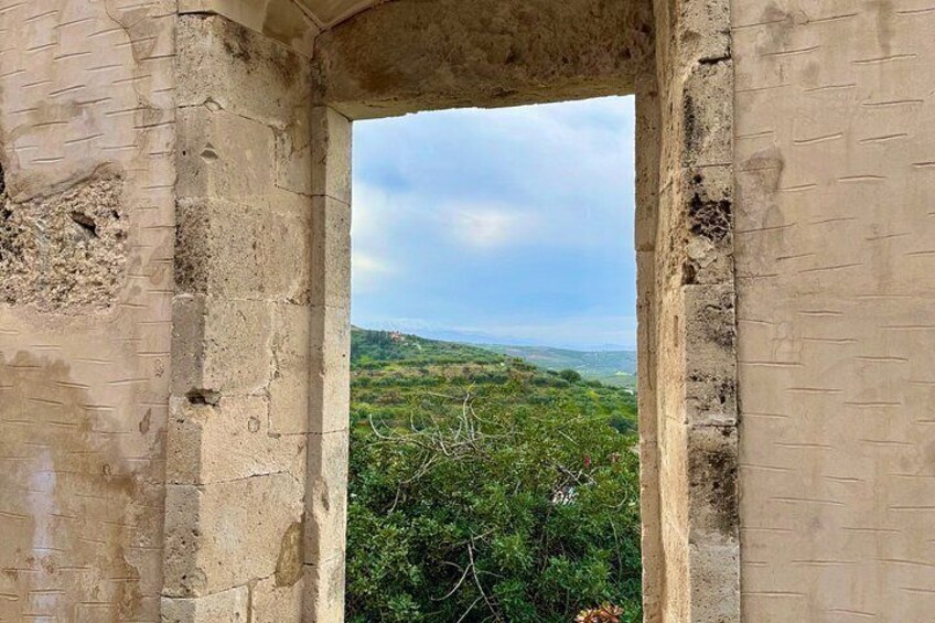 An ancient stone structure with a view of a lush green landscape. 4
