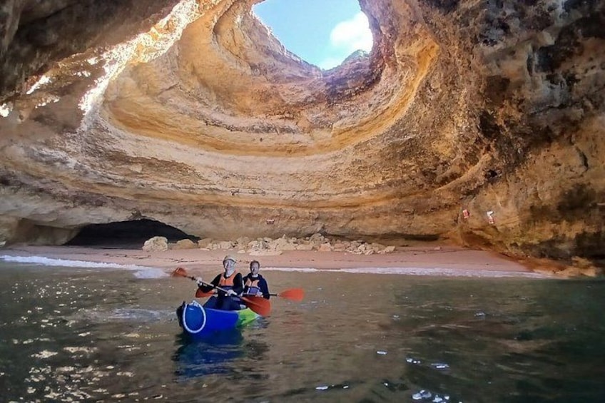 A kayaker navigating through a narrow water channel surrounded by steep, layered rock formations. 4