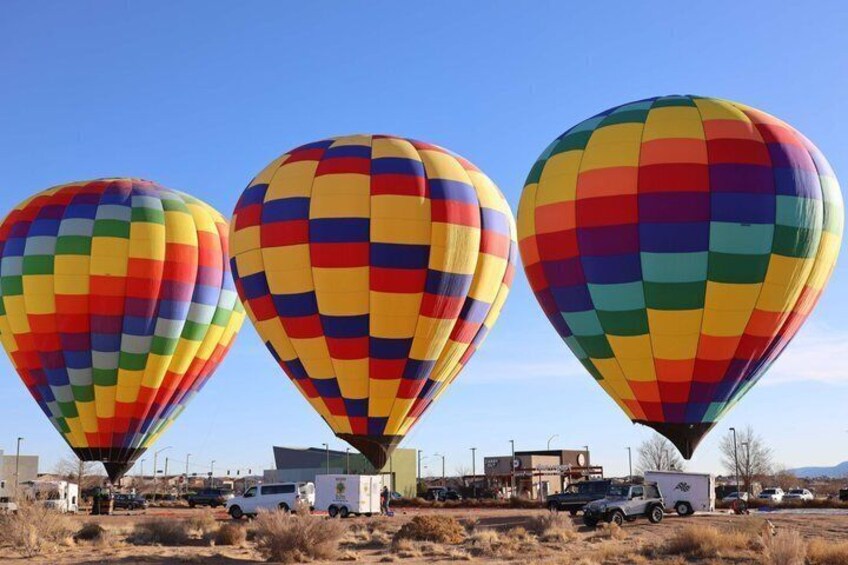 Three colorful hot air balloons in a clear sky. 1