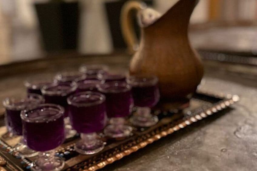 A tray with shot glasses and a wooden pitcher. 4