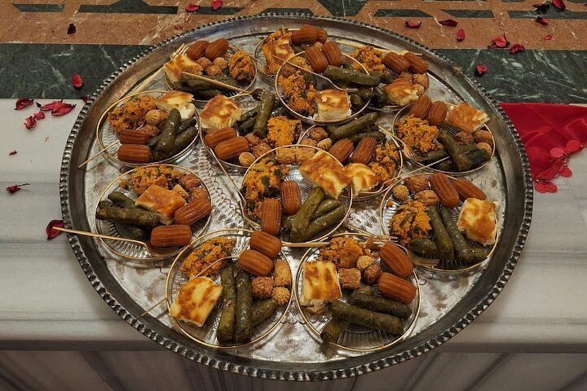A tray of various stuffed vegetables and nuts on a marble surface. 2