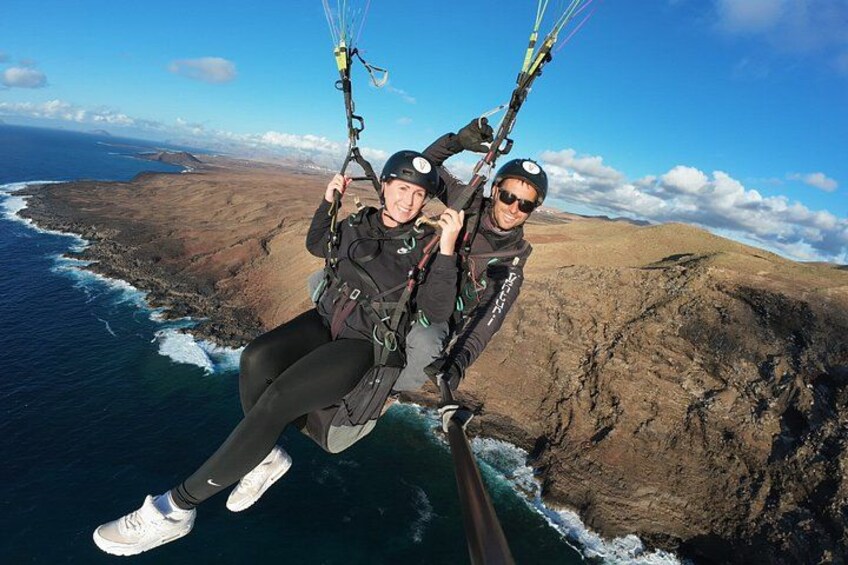 A person paragliding over a coastal landscape with cliffs and ocean. 3