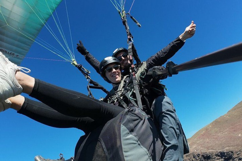 A person skydiving with a parachute, wearing a helmet and harness. 4