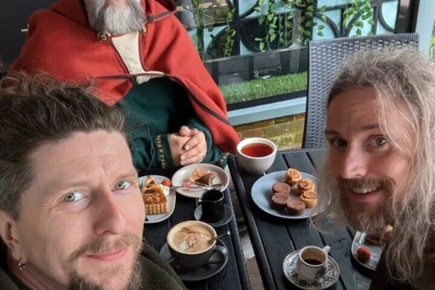 Three people sitting at a table with food and drinks. 5