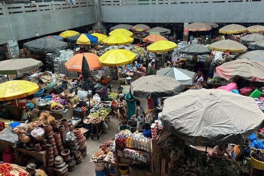 A bustling outdoor market with numerous stalls and colorful umbrellas. 4