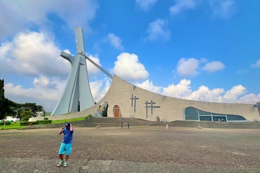 A modern building with a unique design, featuring a large cross and a curved facade. 1