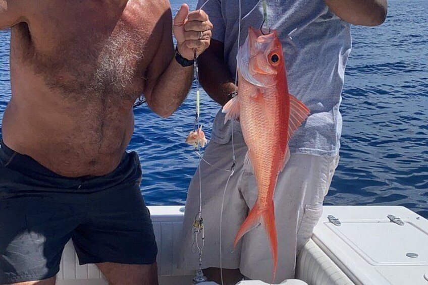 A person holding a fish on a boat. 4